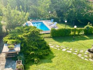 un jardín con una piscina con un árbol grande en Alta Langa Suites en Cortemilia