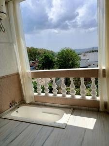 een badkuip in een kamer met een raam bij Hotel ND Manor in Dehradun +17 foto's