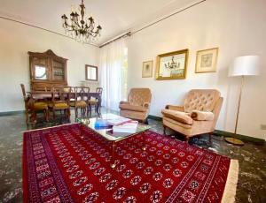 un soggiorno con tavolo, sedie e tappeto rosso di Alta Langa Suites a Cortemilia