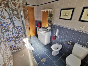 a bathroom with a toilet and a sink at Casa Colina Troviscainho in Sertã +12 photos