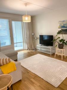 uma sala de estar com um sofá e uma televisão de ecrã plano em JATKASAARI-1 Dream stay on Helsinki seafront em Helsinque