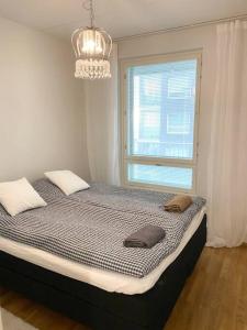 Ce lit se trouve dans un dortoir doté d'une fenêtre et d'un lustre. dans l'établissement JATKASAARI-1 Dream stay on Helsinki seafront, à Helsinki