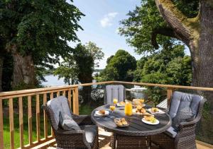 uma mesa com comida e sumo de laranja num deque em Killyhevlin Lakeside Hotel & Lodges em Enniskillen