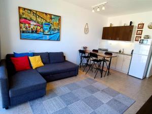 a living room with a couch and a kitchen at By the Sea in Ashkelon