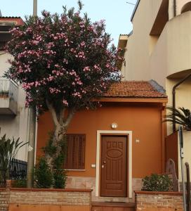 una pequeña casa con un árbol y una puerta en Casa Indipendente, en Villa San Giovanni