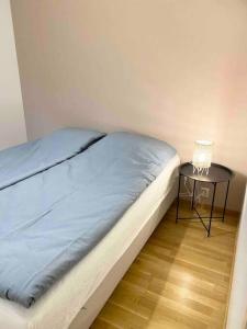 een bed met een nachtkastje naast een bijzettafel bij LAUTTASAARI Top hideaway in Helsinki in Helsinki