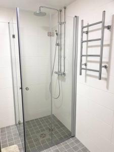 La salle de bains est pourvue d'une douche avec une porte en verre. dans l'établissement LAUTTASAARI Top hideaway in Helsinki, à Helsinki