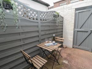 a patio with a table and two chairs and a fence at Amble Watch in Morpeth