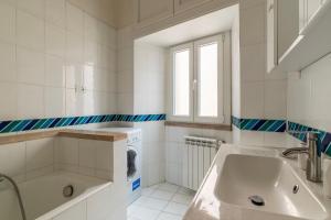 bagno bianco con lavandino e lavatrice di Pantheon Charming Apartment a Roma