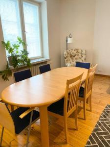 uma mesa de madeira e cadeiras numa sala de estar em KAMPPI - Perfect location right in Helsinki center em Helsinque