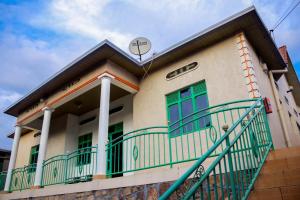 una casa con porte verdi e un balcone di THE PILLAR MOTEL a Kigali