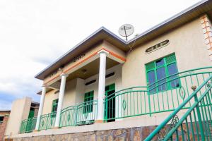 - un bâtiment avec des fenêtres vertes et un balcon dans l'établissement THE PILLAR MOTEL, à Kigali