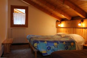 a bedroom with two beds and a window at Chalet Presanella in Temù