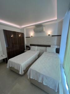 una habitación de hotel con 2 camas en una habitación en Kas Maki Hotel, en Kas