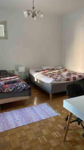 1 dormitorio con 2 camas, escritorio y mesa en VALLILA - Helsinki sleeping beauty, 2 big rooms, en Helsinki