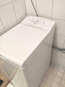 a white sink in a white tiled bathroom at VALLILA - Helsinki sleeping beauty, 2 big rooms in Helsinki