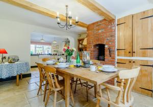 cocina y comedor con mesa de madera y sillas en Woodberry Cottage en Dunwich