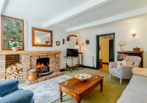 a living room with a fireplace and a table at Woodberry Cottage in Dunwich