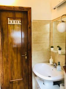 baño con lavabo y puerta de madera en Soggiorno rilassante in montagna en Riolunato