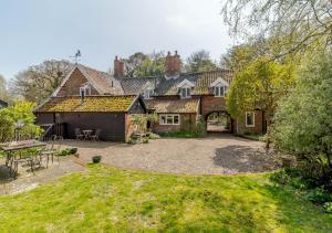 una finca con un gran patio y una casa en Woodberry Cottage en Dunwich