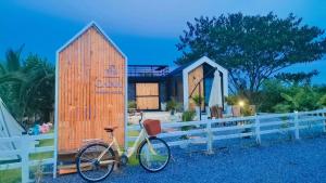 a bike parked in front of a wooden shed at Cana​ Garden​ House​ โฮมสเตย์​ in Ban Khok