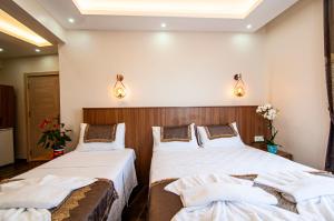 dwa łóżka w pokoju hotelowym z oświetleniem w obiekcie historia hotel w Stambule