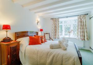 a bedroom with a bed with two teddy bears on it at Woodberry Cottage in Dunwich
