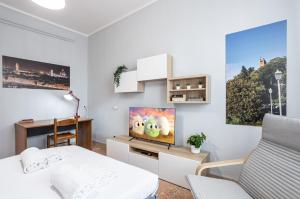 Habitación blanca con cama y TV en Yellowsunny Apartment with Two Balconies, en Pisa