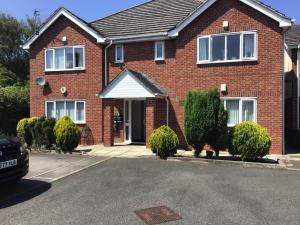 a red brick house with a white awning at Dovedale Apartment in Moreton