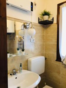 a bathroom with a sink and a toilet and a mirror at Soggiorno rilassante in montagna in Riolunato