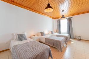 a bedroom with two beds in a room with a window at Prainha Apartments in São Roque do Pico