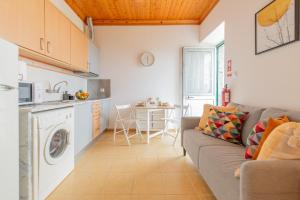 a living room with a couch and a kitchen at Prainha Apartments in São Roque do Pico +36 photos