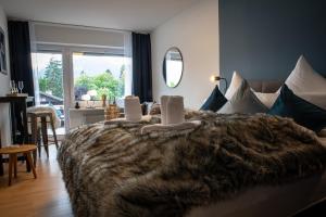 - une chambre avec un grand lit et une couverture brune dans l'établissement Boutique-Appartement Südblick, à Oberstdorf