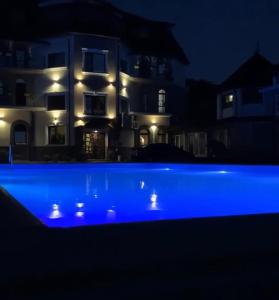 a blue pool in front of a house at night at River Stone Hotel in Sheshory