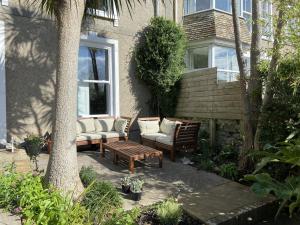 een patio met 2 stoelen, een tafel en een bank bij Porth House, with south facing courtyard garden! in St Ives