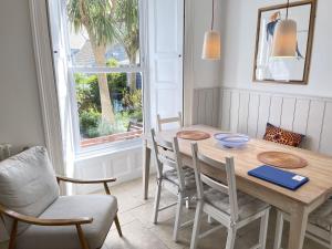 een eetkamer met een tafel en stoelen en een raam bij Porth House, with south facing courtyard garden! in St Ives