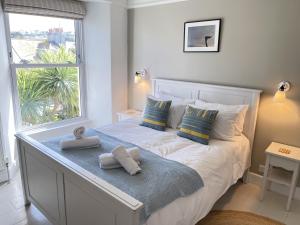 een slaapkamer met een bed met handdoeken erop bij Porth House, with south facing courtyard garden! in St Ives