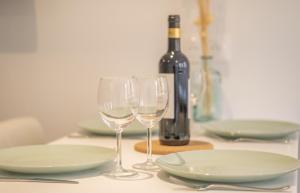 - une table avec 2 verres et une bouteille de vin dans l'établissement Nouveau - Entre Terre et Mer - Centre Ville, à Saverne