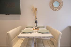 a dining room table with four chairs and a bottle of wine at Nouveau - Entre Terre et Mer - Centre Ville in Saverne