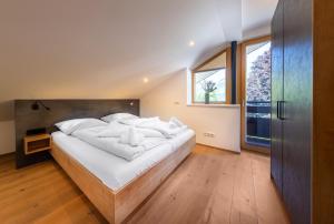 a large white bed in a room with a window at Appartement Gernkogelblick in Wald im Pinzgau