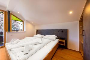 duże białe łóżko w pokoju z oknem w obiekcie Appartement Gernkogelblick w mieście Wald im Pinzgau