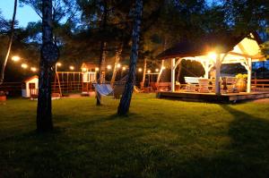 a gazebo with lights in a yard at night at Domki Nad Potokiem574067621 in Ustrzyki Dolne