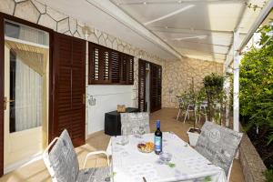 a table and chairs on a patio with a bottle of wine at Balic Apartments - ZF Hvar in Hvar