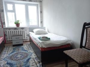 una piccola camera con letto e sedia di Dasha Guest House 2 a Naryn