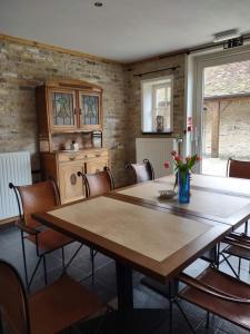 una sala da pranzo con un grande tavolo in legno e sedie di Dielpenhof a Zedelgem