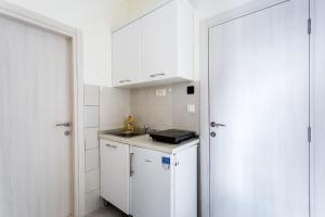 a small kitchen with white cabinets and a sink at Apartments Gloria in Budva