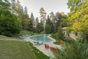 una piscina in un cortile con sedie e una casa di Villa Riva Bellagio with Pool by Rent All Como a Bellagio