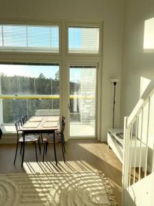 a dining room with a table and chairs and windows at TUUSULA Tuusula 15 min drive to Airport in Tuusula