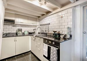 a kitchen with white cabinets and a black counter top at Tiggywinkles in Debenham