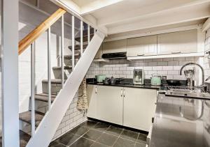 a kitchen with white cabinets and a spiral staircase at Tiggywinkles in Debenham